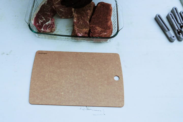 Raw seasoned steaks in a glass dish