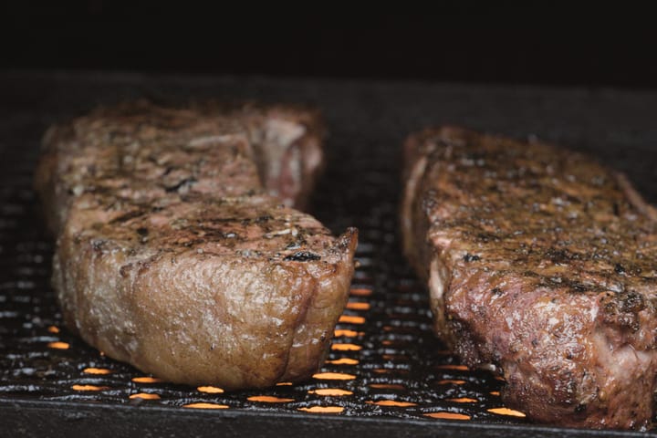 Two steaks over glowing coals